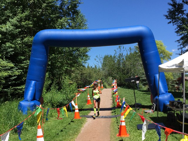 Photo of Patty Bryant crossing the finish line of the Aspen Backcountry Marathon